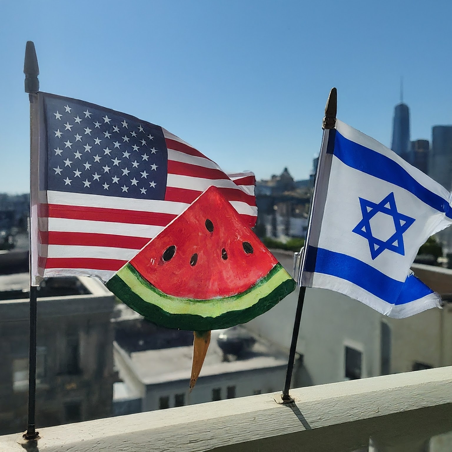 A photo of an American Flag, a painted watermelon slice, and an Israeli Flag