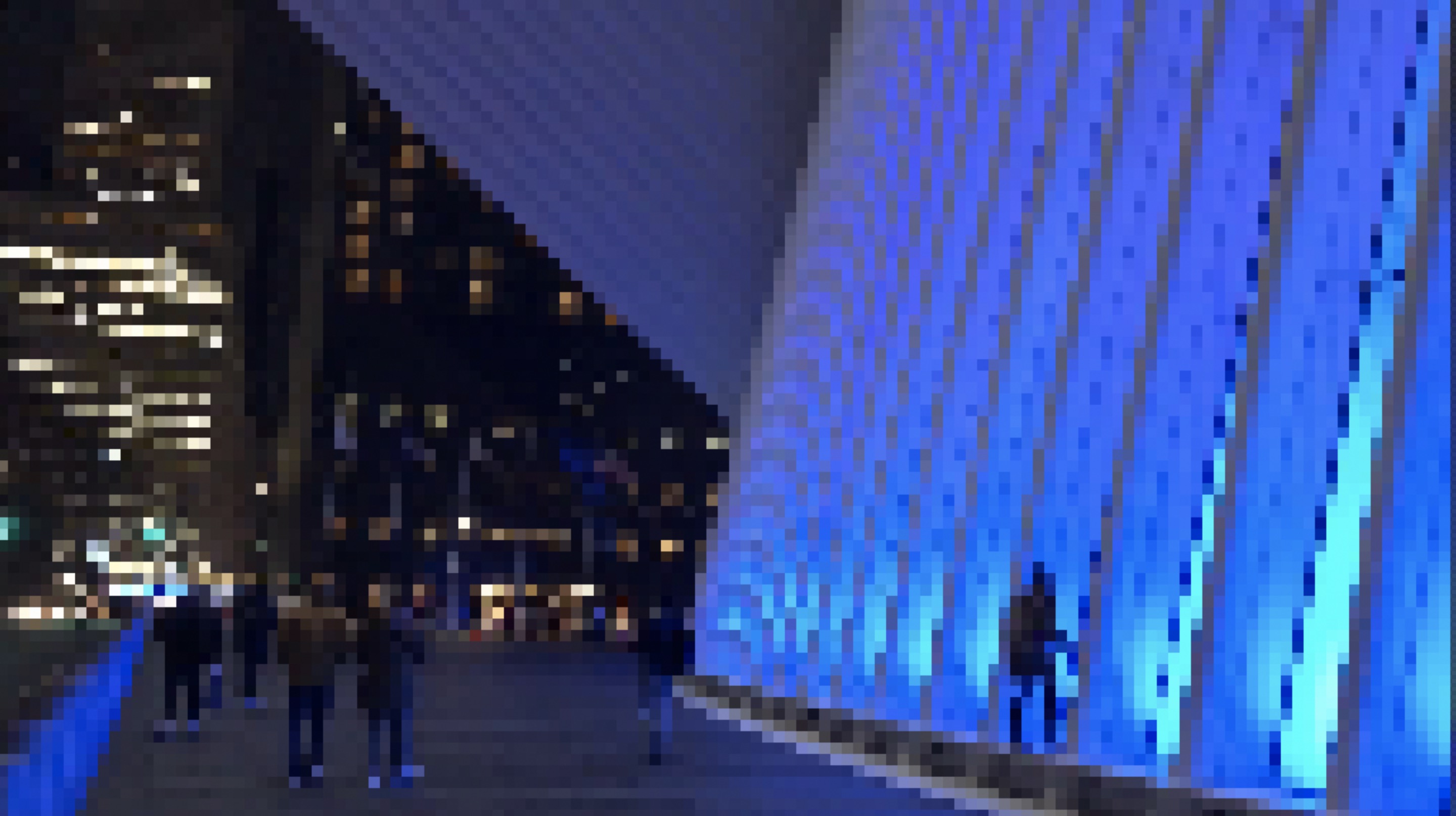 A pixelated photo at night outside the World Trade Center station, with turquoise lights lighting up the station building to the right and people standing on a walkway on the left