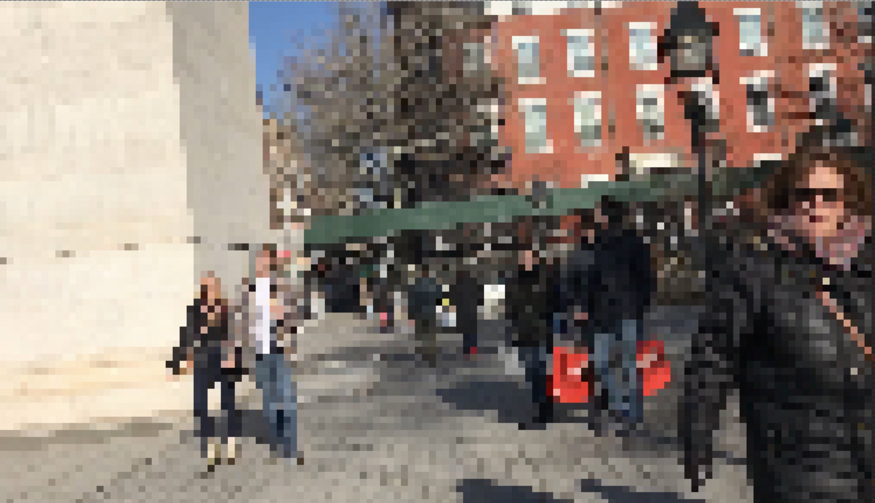 A pixelated photo that includes part of an arc from Washington Square Park, a couple by the arc, and a woman with sunglasses