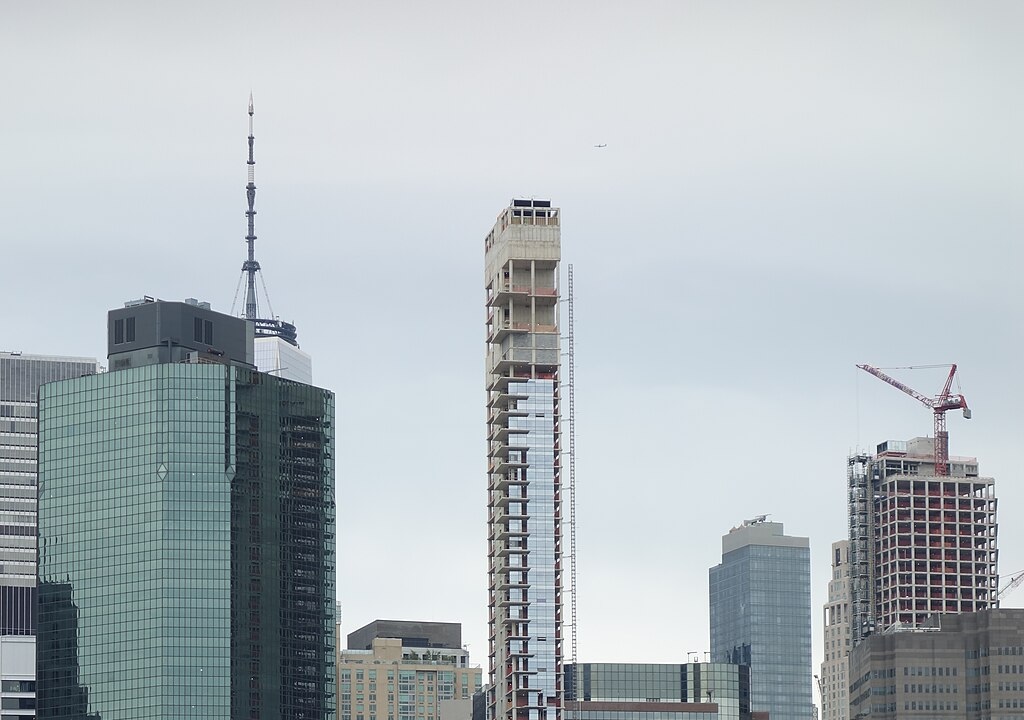 An indigo landcsape with a few mannequin-like figures standing on paths of green arrows floating and looping through space.