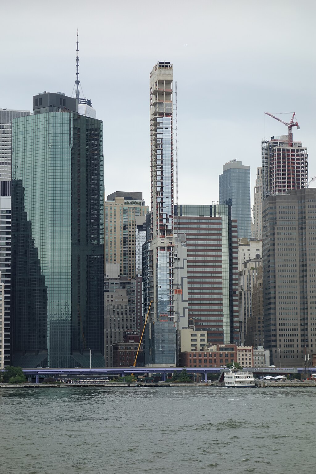 A view from the side of the partially constructed skyscraper, 161 Maiden Lane, among its neighboring skyscrapers.