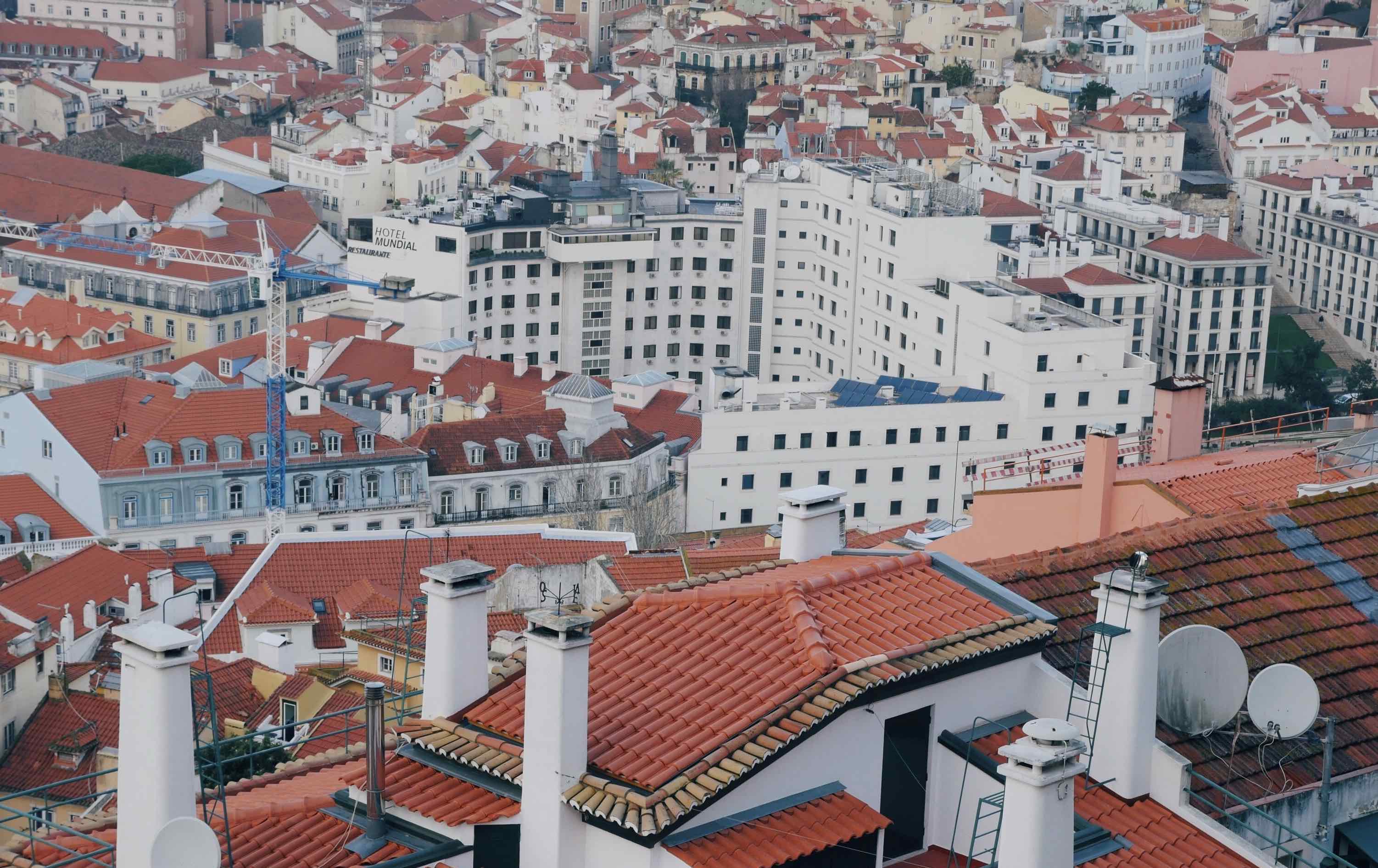 A landscape of buildings in Lisbon withwhite walls and orange roofs